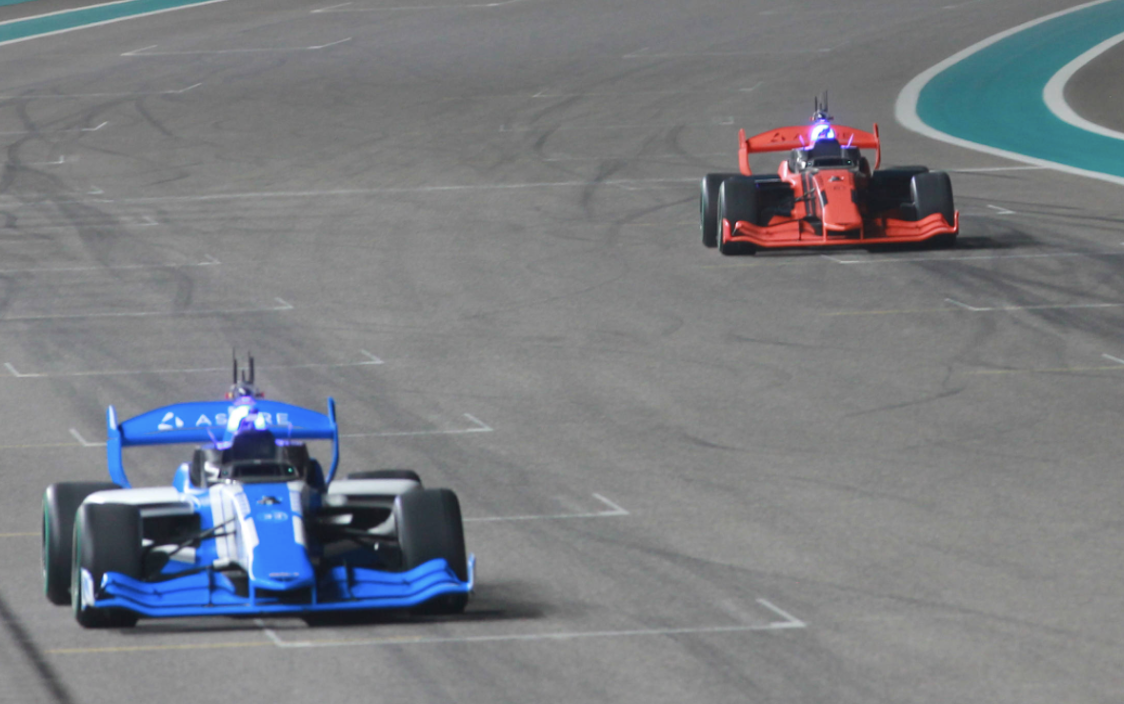 Two A2RL autonomous racecars competing on track